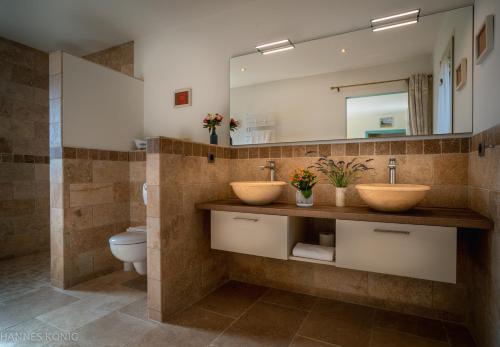 a bathroom with two sinks and a toilet at Les Trois Oliviers in Forcalquier