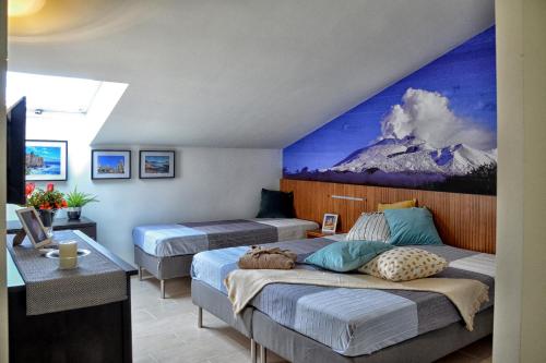 a bedroom with two beds and a painting on the wall at B&B Fossanoce in Belpasso