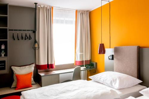 a bedroom with a bed and a window at Vienna House Easy by Wyndham Cracow in Kraków