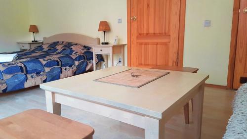a table in a room with a bed at Guest House Vasara in Nida