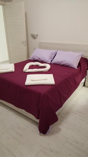 a large bed with purple sheets and towels on it at CA' VEGIA in Gravedona