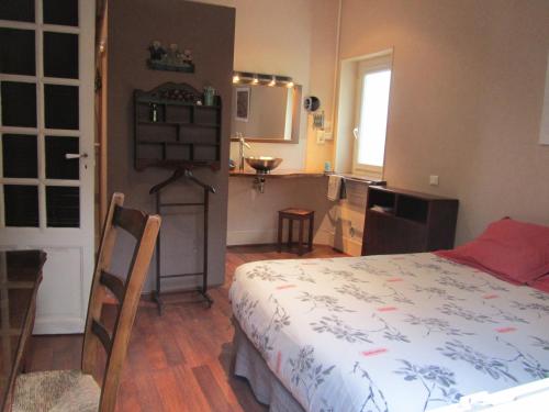1 dormitorio pequeño con 1 cama y cocina en Festiane, en Decazeville