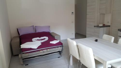 una camera con un letto e un tavolo con sedie bianche di CA' VEGIA a Gravedona