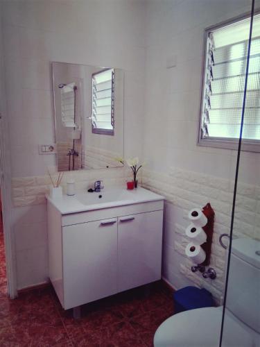 a white bathroom with a sink and a mirror at Casa Belinda in San Nicolás