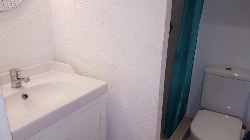 Baño blanco con lavabo y aseo en Casa Pinell Mar 111, en L'Estartit
