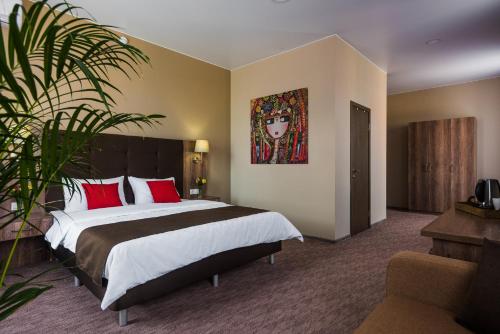 アストラハンにあるGranat Hotelのベッドルーム1室(大型ベッド1台、赤い枕付)