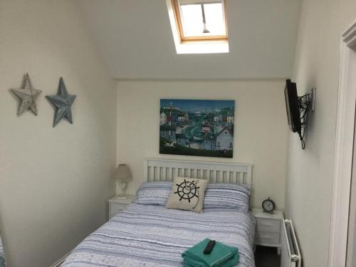 a bedroom with a bed and two stars on the wall at Sma Harbour Hoose in Gourdon