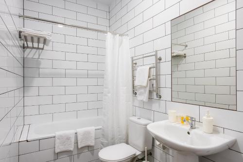 アストラハンにあるGranat Hotelの白いバスルーム(トイレ、シンク付)