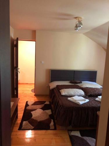 a bedroom with a large bed and a rug at Cabana Cory Râușor in Râu de Mori