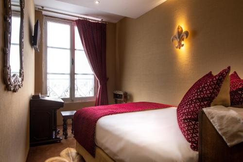 a hotel room with a bed and a window at Le Temple De Jeanne in Paris
