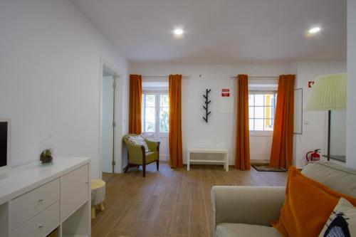 ein Wohnzimmer mit einem Sofa und einem Stuhl in der Unterkunft Casa dos Avós in Villa Nogueira