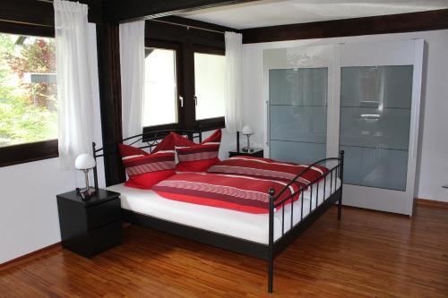 a bedroom with a bed with red pillows at Studio zum Wohlfühlen in Kreuzlingen in Kreuzlingen