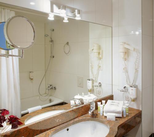 uma casa de banho com um lavatório e um espelho em Hotel Chateau Kurfürstendamm em Berlim