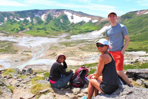 three people sitting on top of a mountain at Sounkyo Hostel in Kamikawa