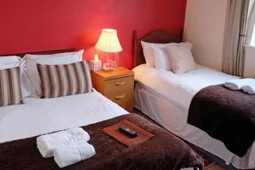 a hotel room with two beds and a remote control at The Old Court Hotel in Witney
