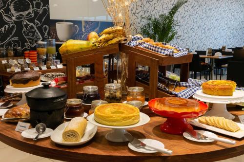 a table topped with different types of cakes and pies at WA Hotel Caruaru in Caruaru