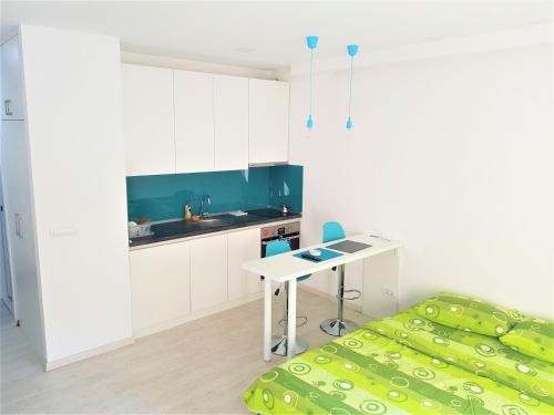 eine Küche mit einem Tisch und einem Bett in einem Zimmer in der Unterkunft Asya Blue Studio in Belgrad