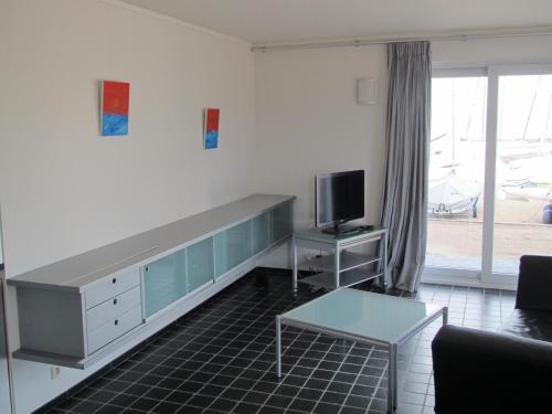 a living room with a desk and a tv at Malibu Beach in Koksijde