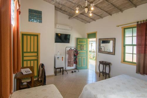 a bedroom with green and white walls and a bed at Pousada da Sirlei in Tiradentes