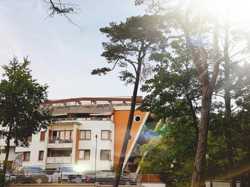 a white building with trees in front of it at Apartament 316 w Domu Zdrojowym in Jastarnia