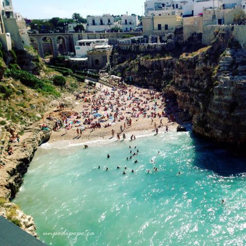 a group of people in the water at a beach at Antiche Mura Apartments"Nido di Puglia" monovano in Turi