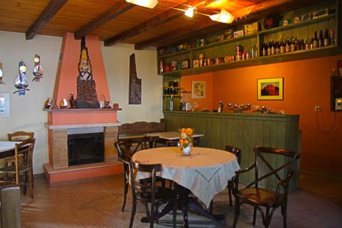 a restaurant with a table and chairs and a fireplace at To Xani in Palaios Panteleimon