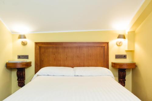 a bedroom with a white bed with two night stands at Hotel El Sella in Cangas de Onís