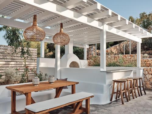 a white pergola with a table and chairs under it at The Asteri Collection -Villa Antilia in Agios Nikolaos