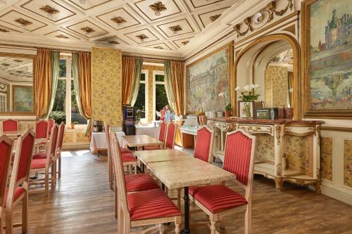 une salle à manger avec des tables et des chaises et un plafond dans l'établissement Hôtel De France Et De Guise, à Blois