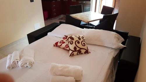 a bed with white sheets and towels on it at La Suite in SantʼAlessio Siculo