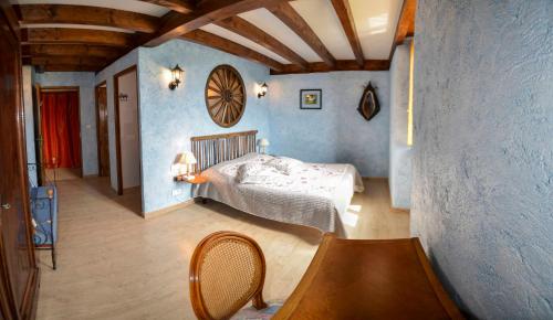 1 dormitorio con 1 cama en una habitación con paredes azules en Ecrin du Ségala en Tauriac-de-Naucelle