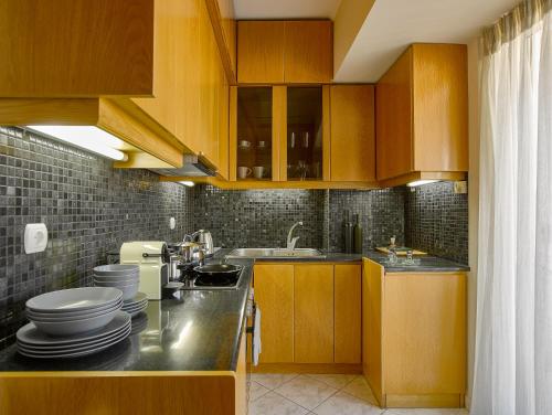a kitchen with wooden cabinets and a sink at Acropolis View Penthouse in Athens