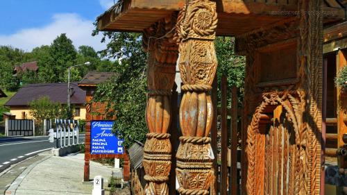 a wooden fence with a wooden carving on it at Pensiunea Anca in Deseşti