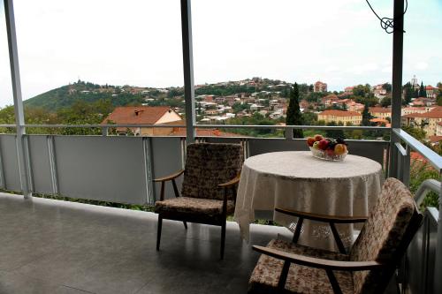 a table with chairs and a bowl of fruit on a balcony at Sighnaghi Inn in Sighnaghi
