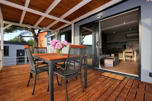 a deck with a wooden table and chairs on it at Mobile homes-Slanica in Murter
