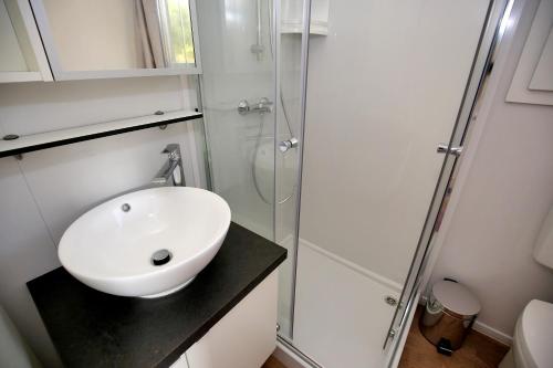a bathroom with a white sink and a shower at Mobile homes-Slanica in Murter