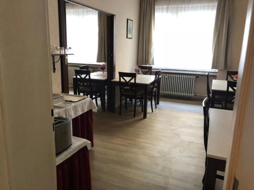 a dining room with tables and chairs and a window at Hotel Berg in Cologne