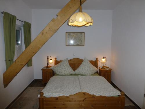 ファーレルにあるLindenhof-Dangastのベッドルーム1室(木製ベッド1台、シャンデリア付)