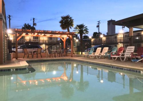 uma piscina com cadeiras e um gazebo em Thunderbird Lodge em Redding