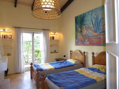 a bedroom with two beds and a painting on the wall at Cas Quinto in Cala Ratjada