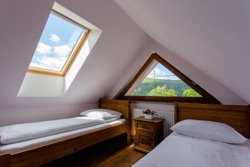 a attic room with two beds and a window at Willa Białka in Szklarska Poręba