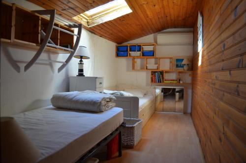 une chambre avec deux lits dans une pièce avec des plafonds en bois dans l'établissement Coquette Maisonnette Centre Ville La Londe Les Maures, à La Londe-les-Maures