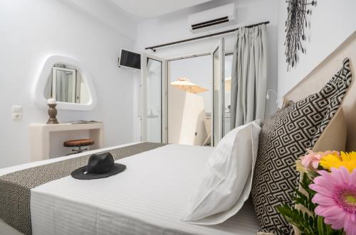 a bedroom with a bed with a hat on it at Naxos Dream Oniro Studios - Adults Only in Naxos Chora