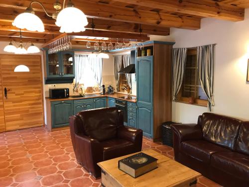 sala de estar con 2 sillas de cuero y cocina en Balaton Rustic Guesthouse en Badacsonytördemic