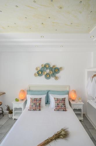 a bedroom with a large white bed with two tables at Naxos Dream Oniro Studios - Adults Only in Naxos Chora