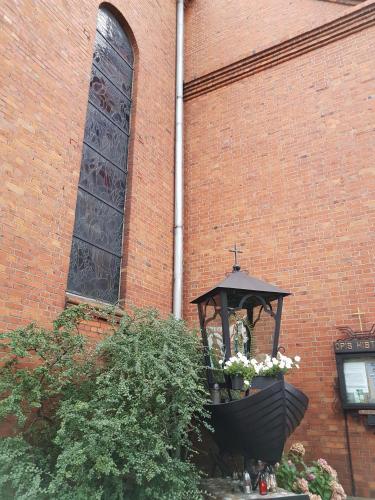 a planter with flowers in front of a brick building at Apartament 316 w Domu Zdrojowym in Jastarnia