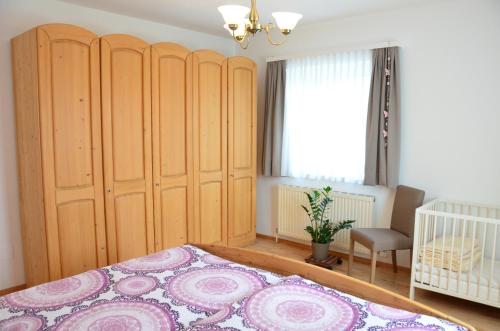 a bedroom with a large bed and a crib at Ferienwohnung Fam. Lerch in Sankt Stefan ob Stainz