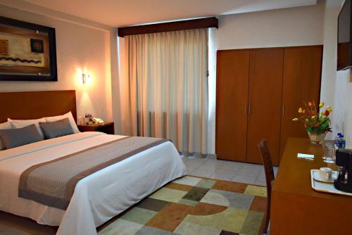 a hotel room with a large bed and a desk at Best Western Global Express in Veracruz