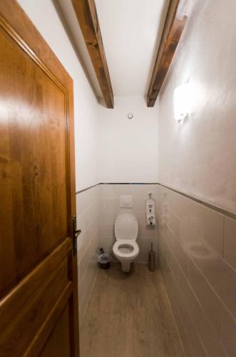 ein Badezimmer mit einem WC und einer Holztür in der Unterkunft Ecrin du Ségala in Tauriac-de-Naucelle