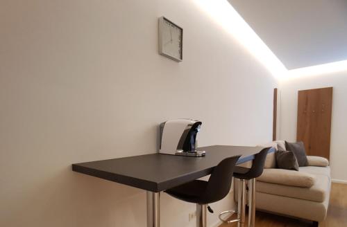 a black desk with a computer on it next to a couch at Seesuiten Mörbisch in Mörbisch am See